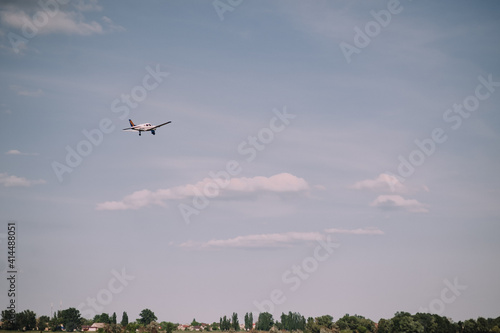 small plane flies in the sky, clouds, field