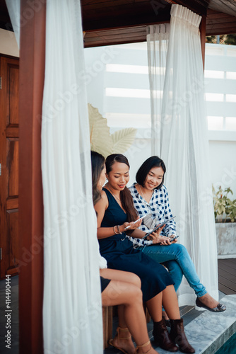 Luxurious and modern villa in Thailand. Group of three asian women dressed in formal clothing with tablet working together.