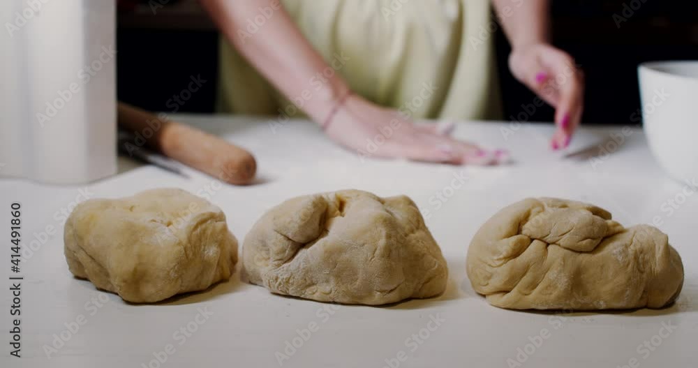 a raw dough on the white wooden table in the kitchen, cooking food. Slow motion. a raw dough on the white wooden table in the kitchen, cooking food. Slow motion.