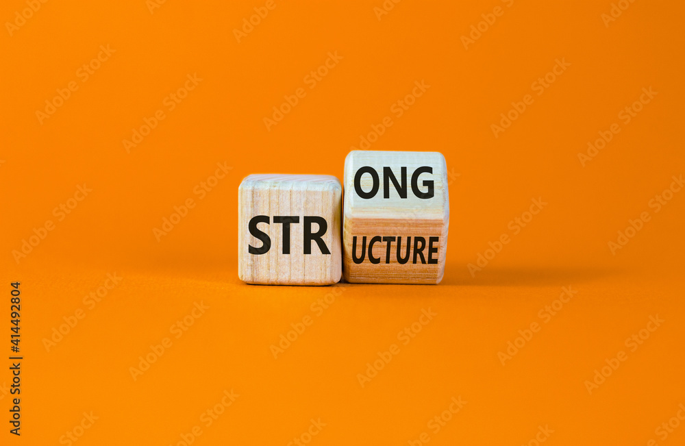 Strong structure symbol. Turned a wooden cube with words 'strong structure'. Beautiful orange background, copy space. Business and strong structure concept. Strong structure symbol. Turned a wooden cube with words 'strong structure'. Beautiful orange background, copy space. Business and strong structure concept.