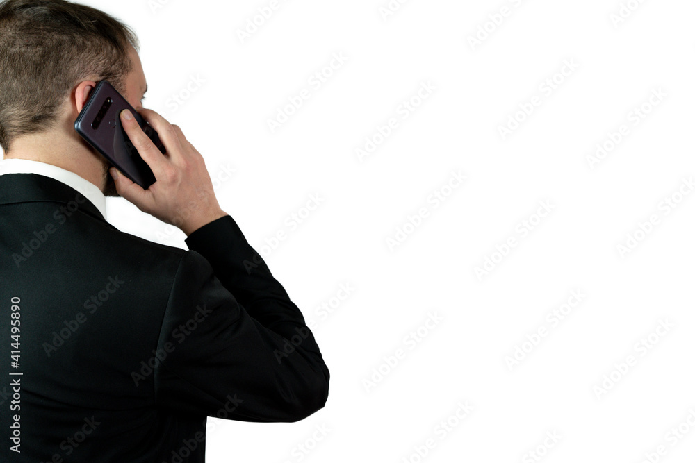 A young businessman in formal wear having a mobile conversation