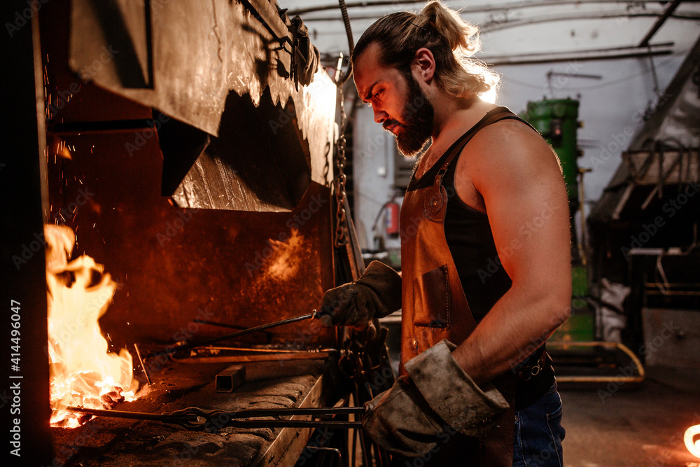 The blacksmith in the furnace heats the metal for further work