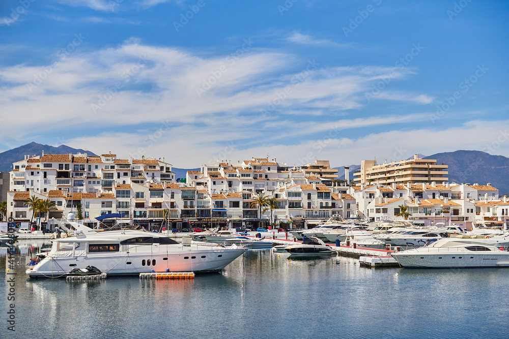 View of Puerto Banus marina with boats and white houses in Marbella town at sunrise, Andalusia, Spain
