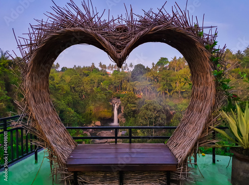 Love shaped sit for couple tourist in bali with the Tegenungan waterfall in the background in Indonesia