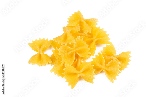 A variety of types and shapes of Italian pasta. Dry pasta bows farfalle. Heap of bow tie macaroni isolated on white background. Butterfly pasta.