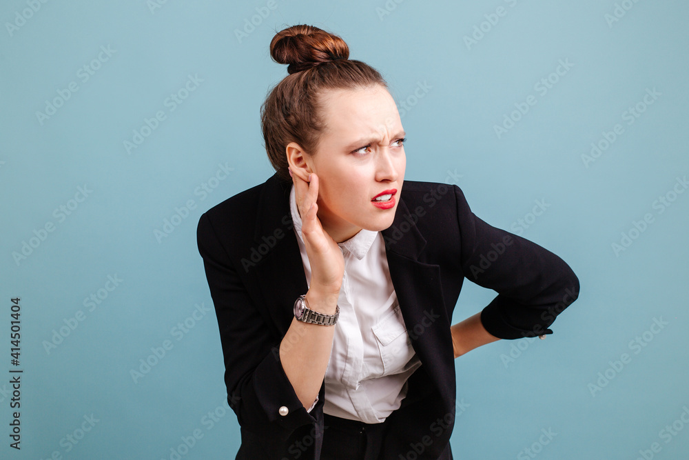 Φωτογραφία The girl in the black suit raised her hand to her ear, trying to hear the sounds