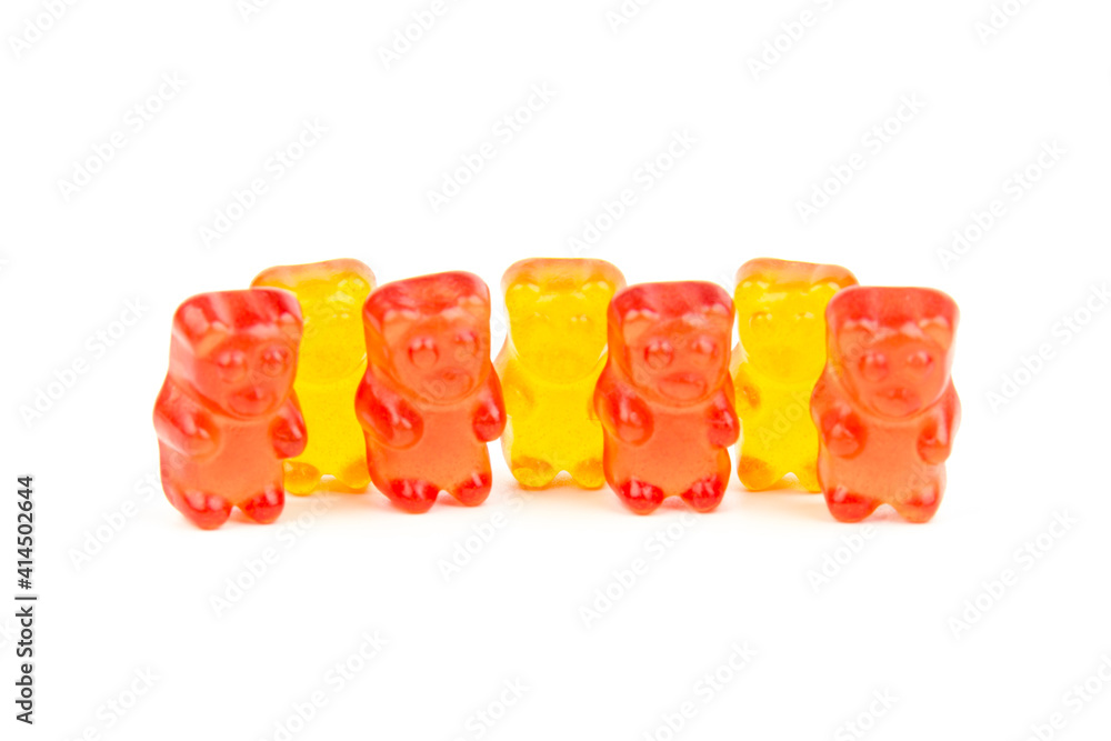Children's vitamins in the form of bears are arranged in rows. A lot of multi-colored jelly sweets for children.