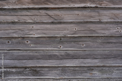 close up of an old wooden log building with gray old logs