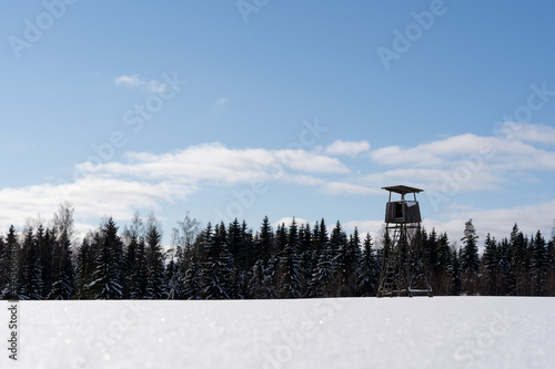 white fluffy snow and on it stands a large hunting tower built of wood