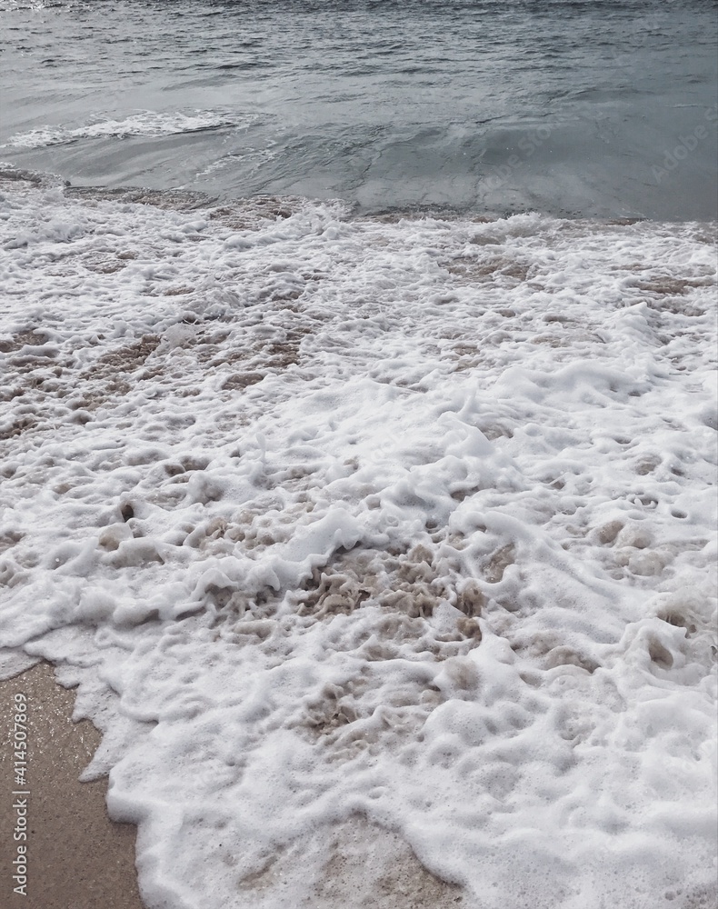 Vertical photo of amazing beach with foamy waves. Indian ocean and sand on Bali island. Vertical photo of amazing beach with foamy waves. Indian ocean and sand on Bali island.
