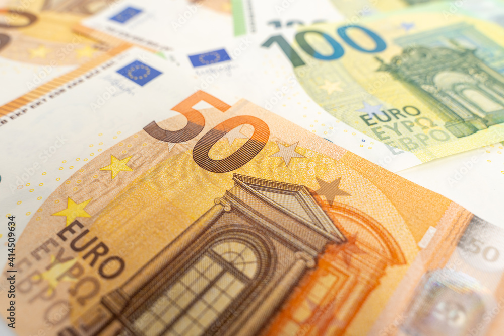 Banknotes background. Fifty and one hundred Euro notes in orange and green color covering the floor. Currency of Europe. Banknotes background. Fifty and one hundred Euro notes in orange and green color covering the floor. Currency of Europe.