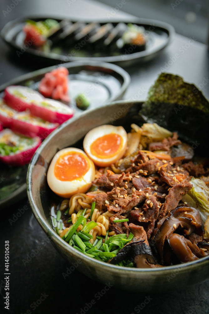 Japanese ramen on the background of sushi rolls, close-up Japanese ramen on the background of sushi rolls, close-up