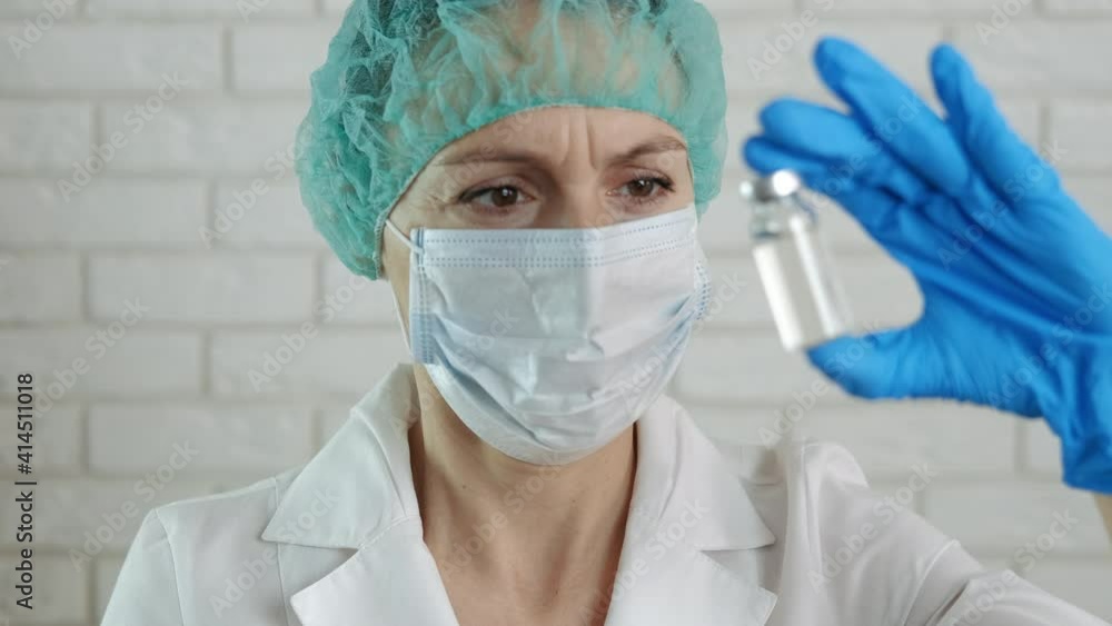 Coronavirus vaccine. The doctor looks at the vial of the vaccine. Coronavirus vaccine. The doctor looks at the vial of the vaccine.