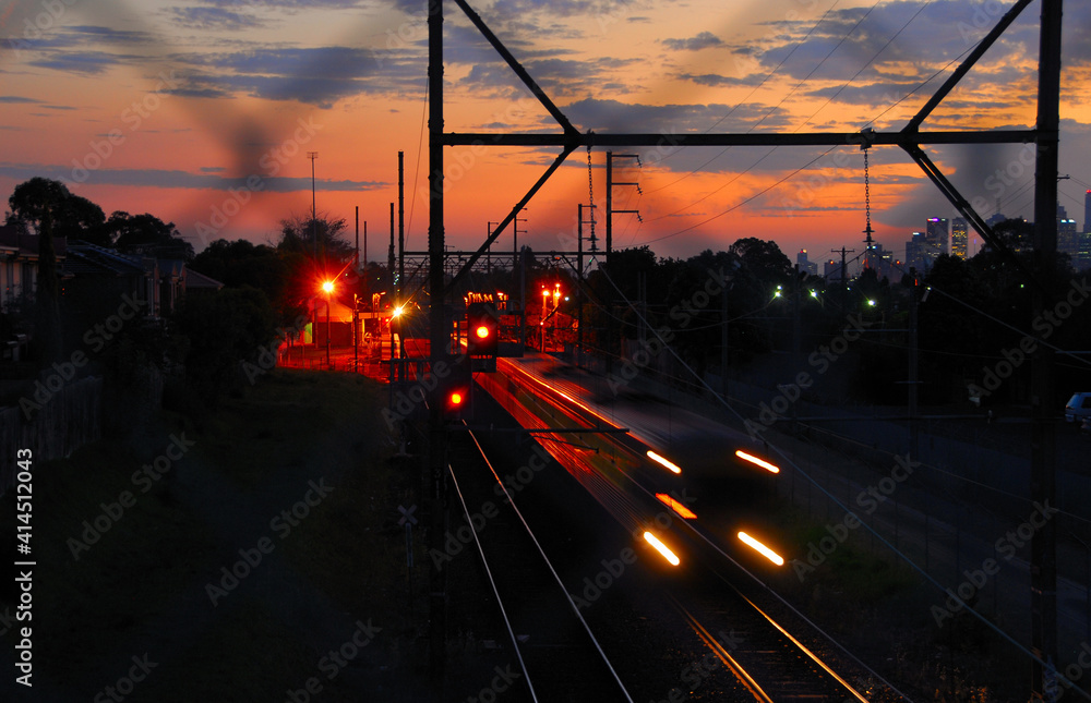 Naklejka premium Commuter train leaving the Thornberry railway station at dusk in Melbourne, Australia