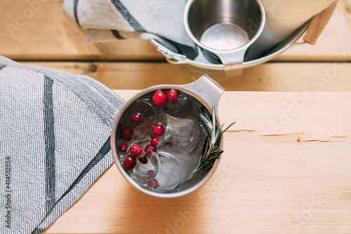 Lingonberry drink in a metal mug for finnish sauna