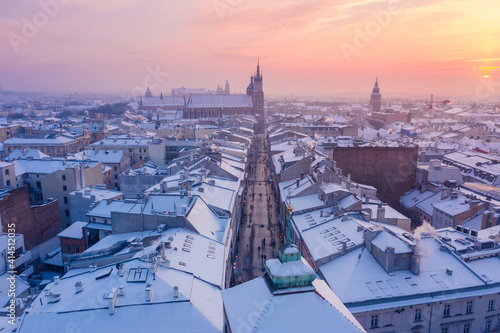 Krakow Old Town in winter. Snow on roofs at Old Town in winter Krakow Poland at sunset. Main tourist walking street, historical main city square Rynek, Royal Road and churches.