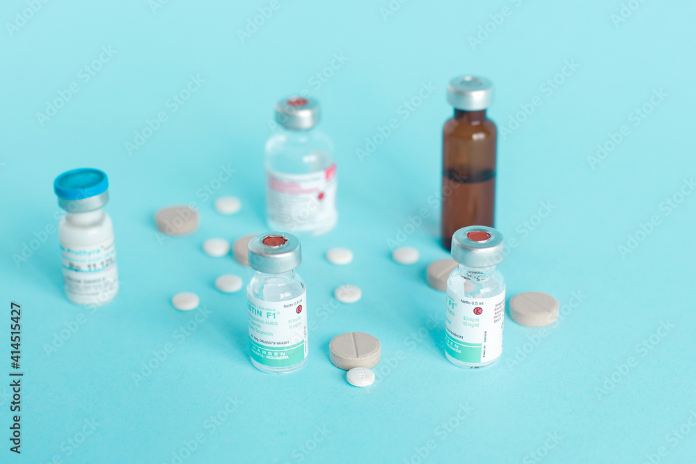 Various medical ampoule and pills isolated on blue background. Various medical ampoule and pills isolated on blue background.