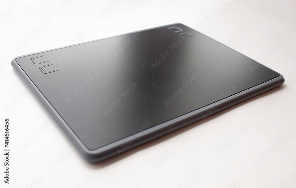 Black graphic design tablet. A graphic tablet at an angle for working on a computer. Black graphic design tablet. A graphic tablet at an angle for working on a computer.