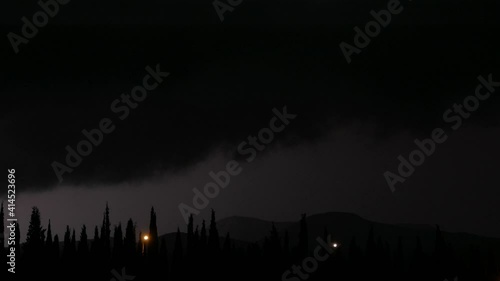 Thunderstorm at summer night. Lightning flashes over the park on summer rainy night