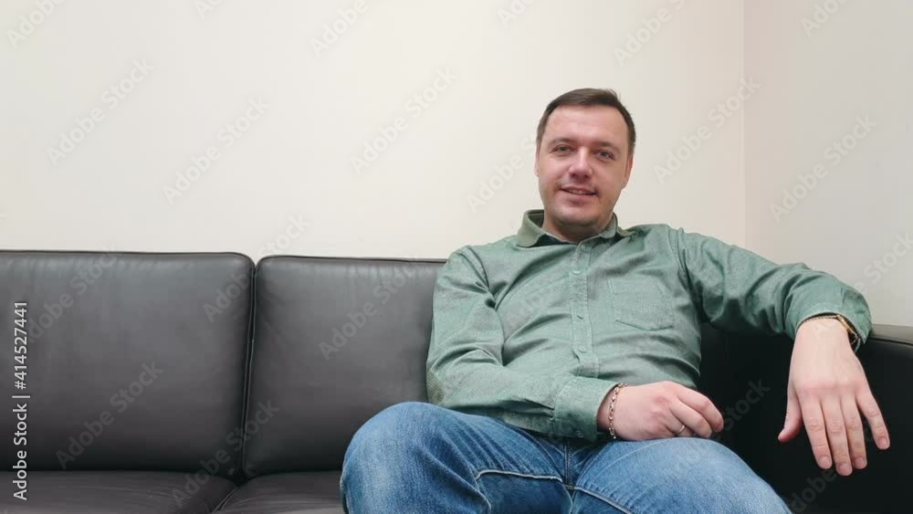 Portrait of man looking at camera and noding at home. Man looking to camera, sitting at office indoors alone Portrait of man looking at camera and noding at home. Man looking to camera, sitting at office indoors alone