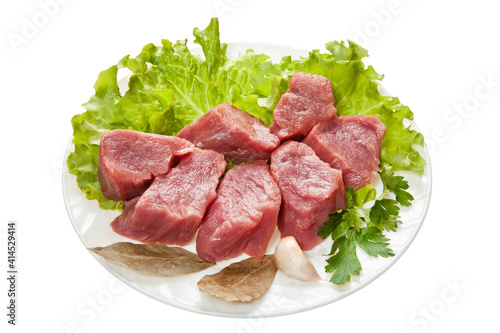 Pieces of raw meat on a white plate is isolated on a white background