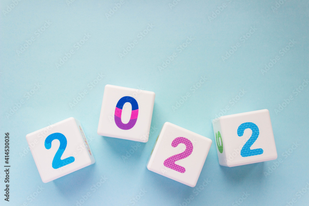 Cubes with colorful numbers 2022 on a blue background. New year, calendar. With copy space Cubes with colorful numbers 2022 on a blue background. New year, calendar. With copy space