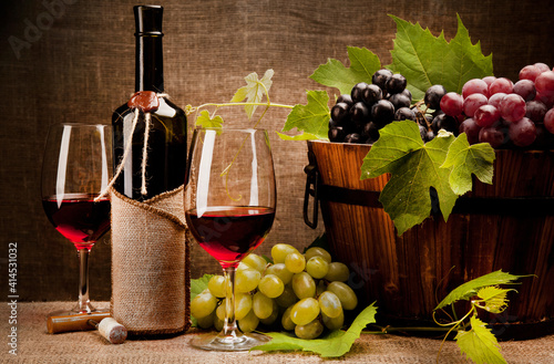 Still life with wine bottles, glasses and grapes
