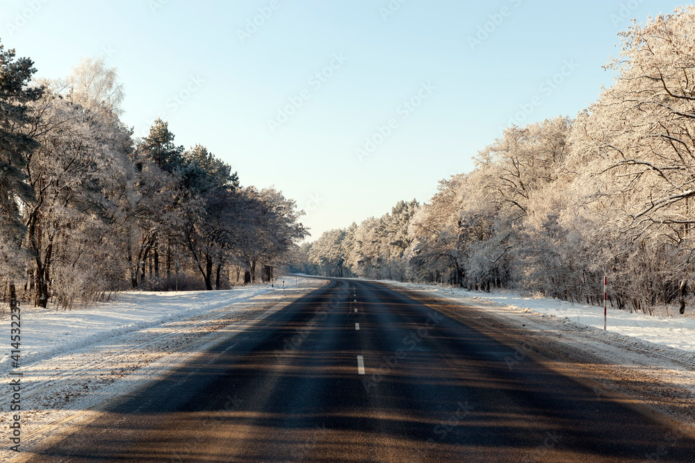 Fototapeta premium snowfall in the winter season and road asphalted