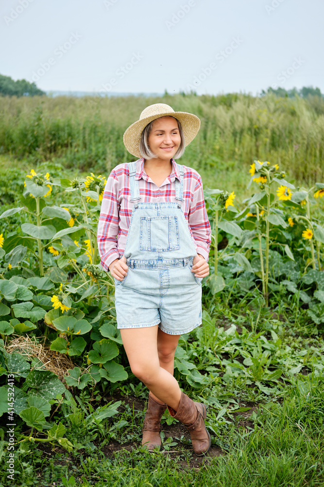 Woman wearing in hat standing on Organic Bio Farm. Autumn Vegetable Harvest.