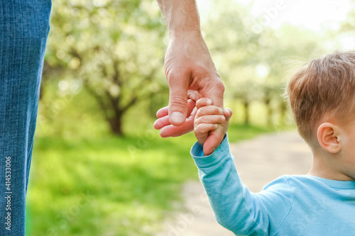 the parent holding the child's hand with a happy background