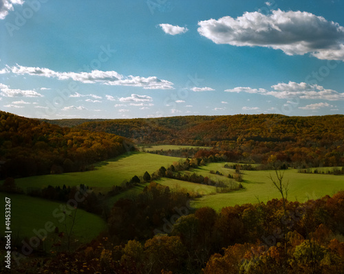 View of an Ozarks meadow in Autumn with leaves beginning to turn and puffy clouds from a ridge above Akers  Missouri  and Current River on Highway K.