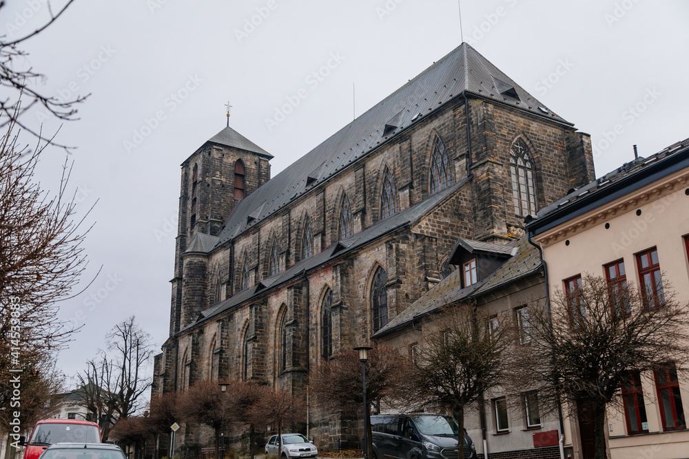 Gothic stone church of the Nativity of the Virgin Mary in winter day, cityscape of medieval town with historical buildings, Bohemian Paradise, Turnov, Czech Republic Gothic stone church of the Nativity of the Virgin Mary in winter day, cityscape of medieval town with historical buildings, Bohemian Paradise, Turnov, Czech Republic