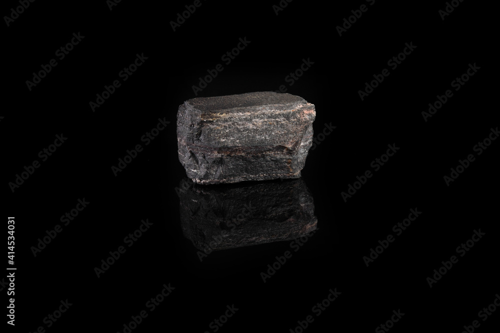 Metamorphic rock specimen - jaspillite jaspilite, ferruginous quartzite, jespillite mineral from Kursk Magnetic Anomaly, Mikhailovskoe, Russia on black glass background. Metamorphic rock specimen - jaspillite jaspilite, ferruginous quartzite, jespillite mineral from Kursk Magnetic Anomaly, Mikhailovskoe, Russia on black glass background.