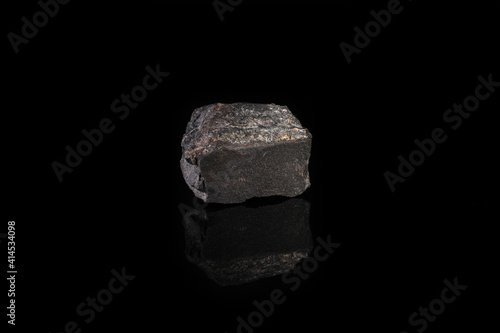 Metamorphic rock specimen - jaspillite jaspilite, ferruginous quartzite, jespillite mineral from Kursk Magnetic Anomaly, Mikhailovskoe, Russia on black glass background.