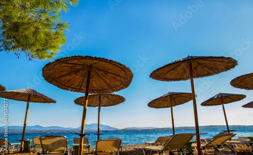 sunshade awnings and beach loungers on the amazing beach on idyllic greek island Spetses