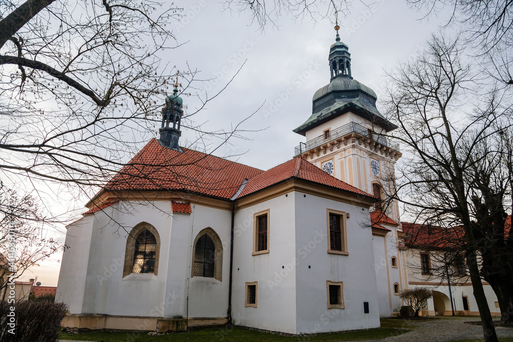 Church of the Nativity of the Virgin Mary near renaissance castle, chateau with park, footpath in garden on sunny winter day, Benatky nad Jizerou, Central Bohemian, Czech Republic
