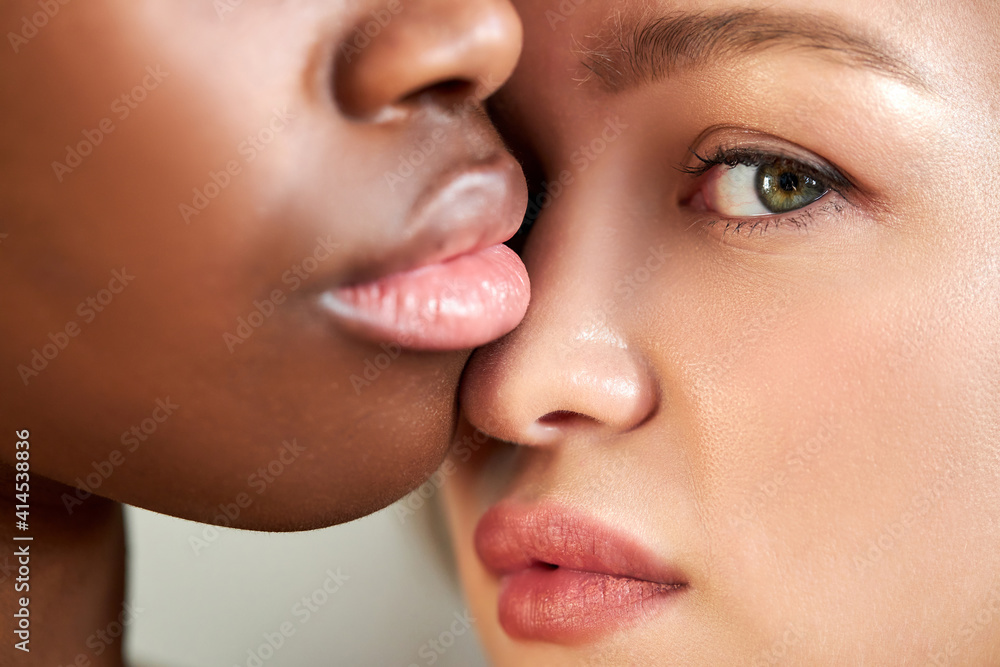 Obraz premium close-up portrait of interracial lgbt couple posing closely to each other, african female with big sweet lips and caucasian tender lady looking at camera