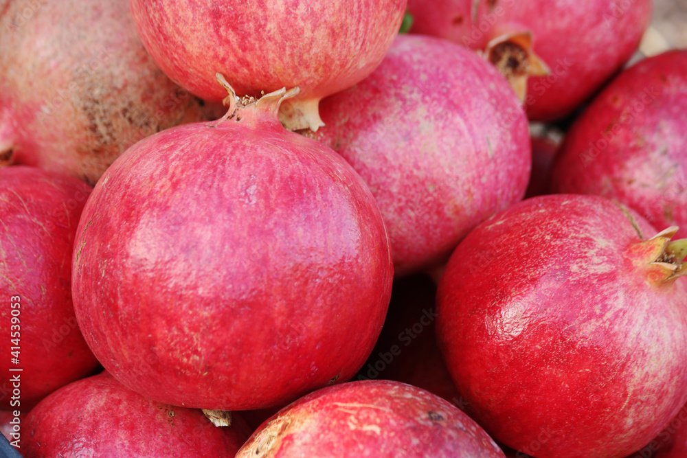 Ripe pomegranate fruits background. Fresh red pomegranates at grocery store. Organic food concept. Ripe pomegranate fruits background. Fresh red pomegranates at grocery store. Organic food concept.