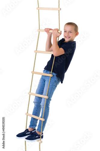 Teenage boy climbiing on rope ladder