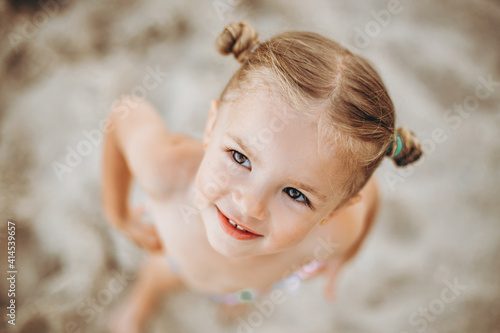 Portrait of a little 3-year-old girl posing for a photo by the sea during swimming  sunbathing and summer vacation