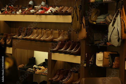 Shoes store at the shopping mall. Variety of female boots and handbags on the shelves.