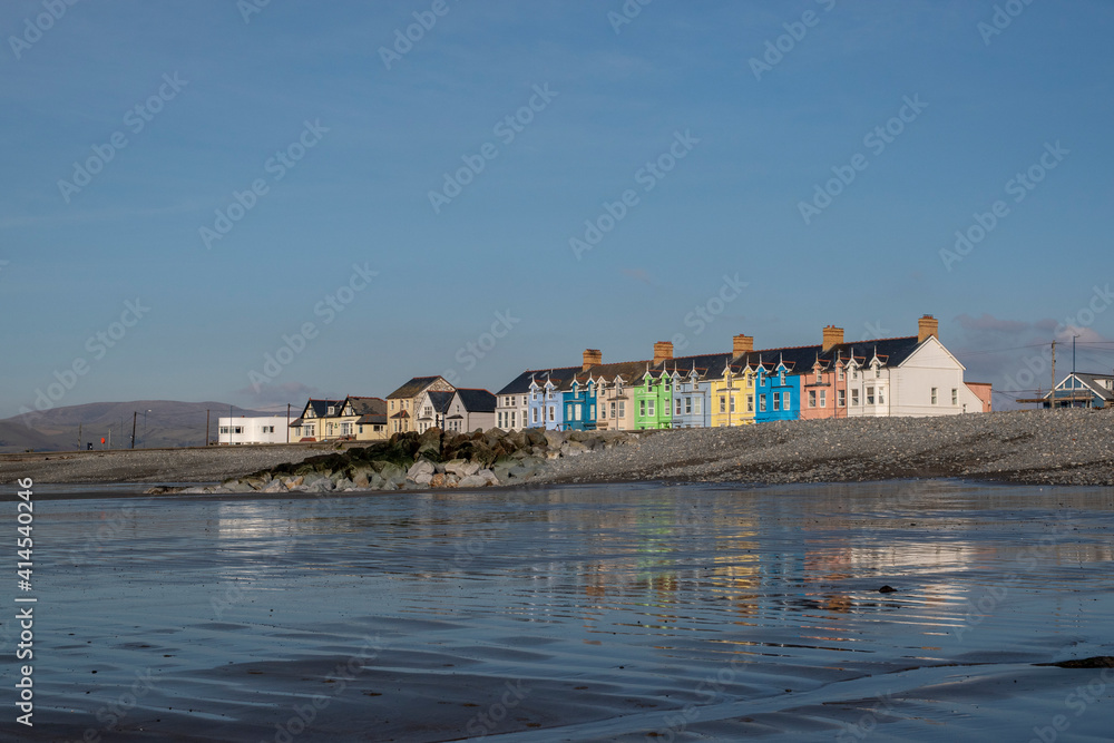 the row of coloured houses in Borth reflected in the sands