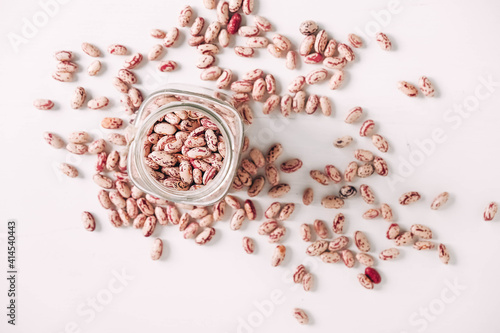 Dry beans in a glass jar on a white table background. Top view. Copy, empty space for text