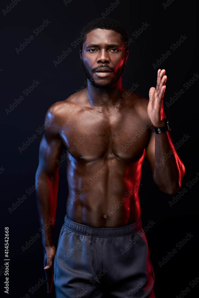 confident black sportsman running, isolated on black background. muscular strong male engaged in sport, have athletic body