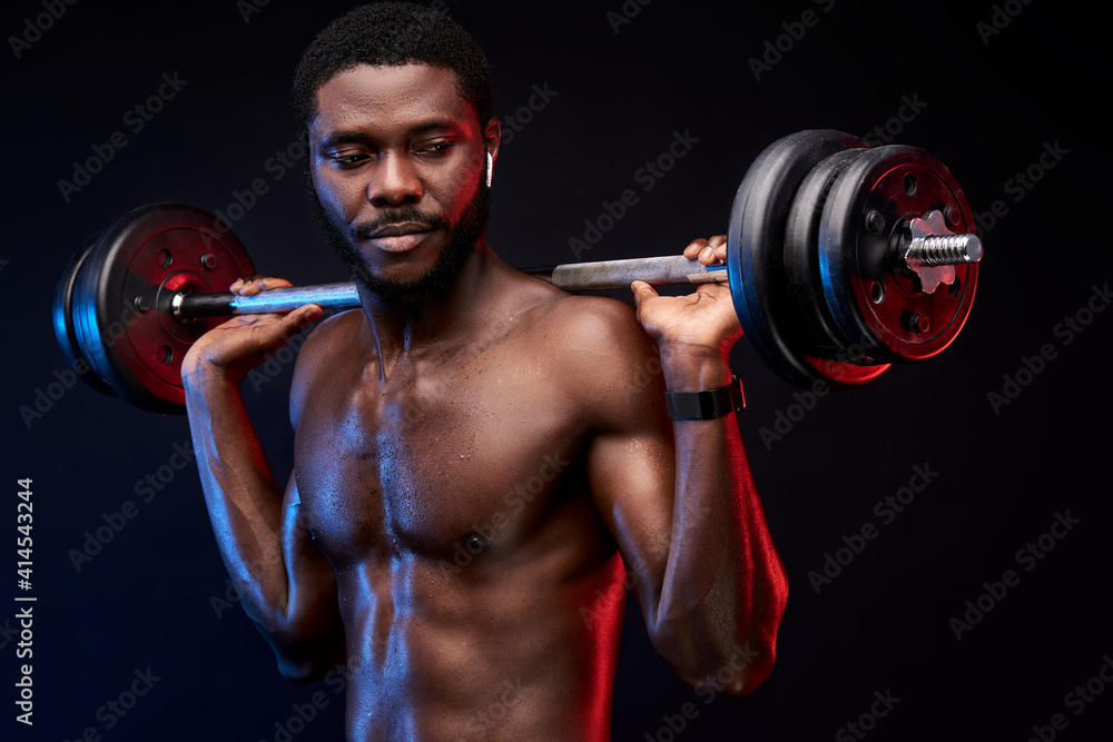 african american bodybuilder with weights in hands, wearing headphones. weightlifting and sport concept.