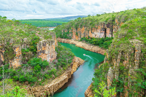 Tourist boat navigating between the Canyons of Furnas, Capitólio MG Brazil. Beautiful landscape of eco tourism of Minas Gerais state. Walls of sedimentary rocks and the green water of Lake of Furnas