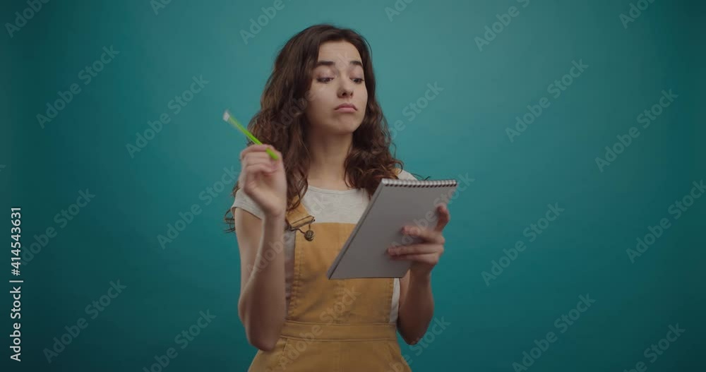 Happy beautiful student girl in summer dress making notes Happy beautiful student girl in summer dress making notes