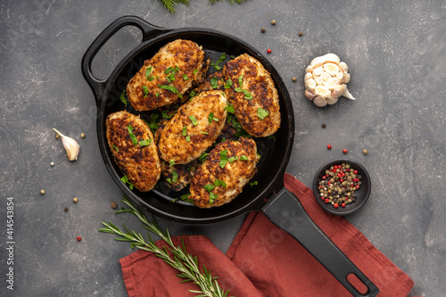 Meat cutlets in frying pan over background. Herbs and spices. Top view, flat lay. High quality photo