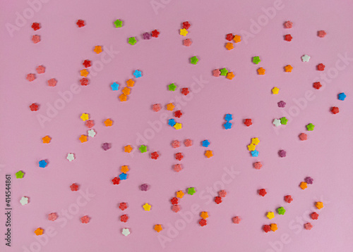 Colorful sweet confetti flowers on pink backgroud.