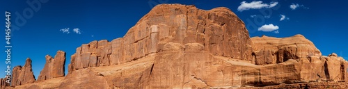 Panorama shot of red sandstone massif and monoliths against blue sky in Archen national park in Utah, america